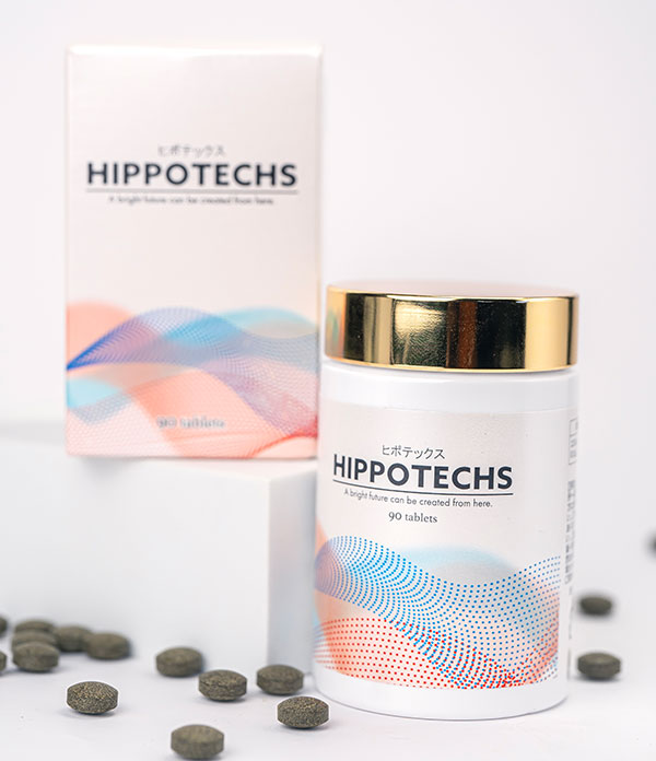 A bottle and box of Hippotechs tablets are displayed, featuring a modern design with wavy patterns in blue, pink, and orange. The bottle has a gold cap, and several tablets are scattered around on a white surface.